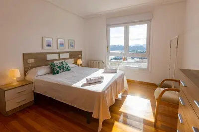 a bedroom with a bed and a large window at Apartagal-Edificio Celtas Foz in Foz