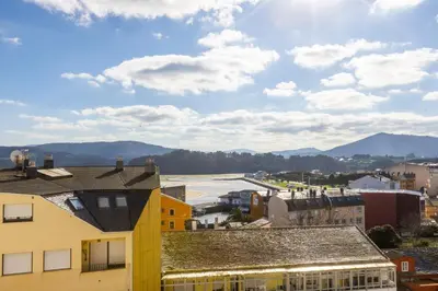 a view of a city with mountains in the background at Apartagal-Edificio Celtas Foz in Foz