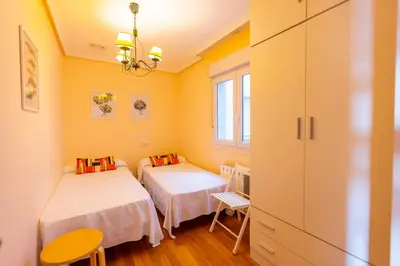 two beds in a room with yellow walls at Apartagal-Edificio Celtas Foz in Foz