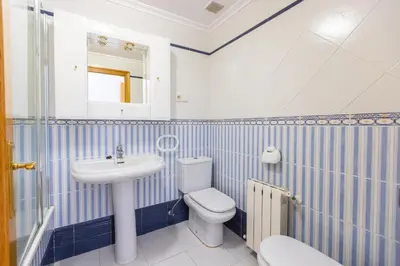 a blue and white bathroom with a toilet and a sink at Apartagal-Edificio Celtas Foz in Foz