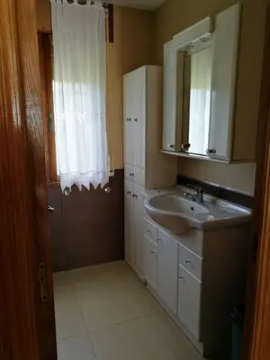 a bathroom with a sink and a mirror at Chalet vacacional en segunda linea de playa in Foz