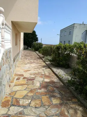 a stone walkway in front of a building at Chalet vacacional en segunda linea de playa in Foz