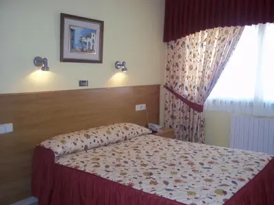 a hotel room with a bed and a window at Hotel Suiza in Arzúa