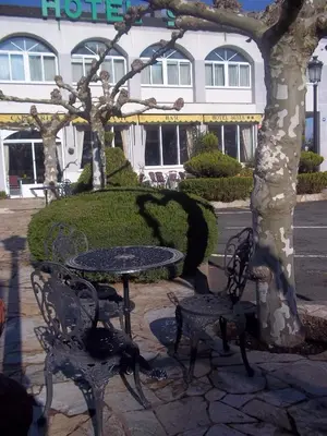 a table and chairs in front of a building at Hotel Suiza in Arzúa