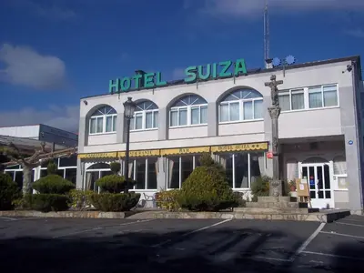 a hotel with a sign on top of a building at Hotel Suiza in Arzúa