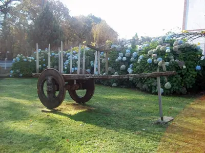 a statue of a wagon in front of a garden at Hotel Suiza in Arzúa