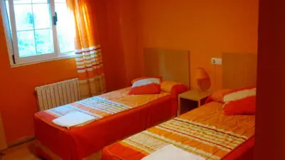 a bedroom with two beds and a window at pension compas in O Pedrouzo