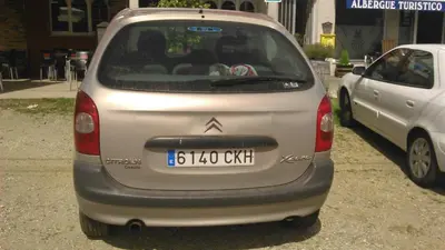 a small silver car parked in a parking lot at pension compas in O Pedrouzo