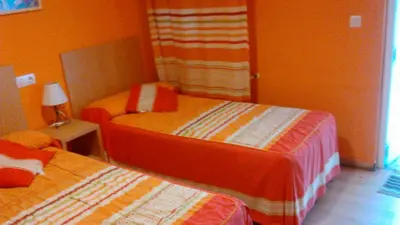 a hotel room with two beds and a window at pension compas in O Pedrouzo