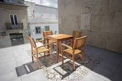 a wooden table and four chairs on a patio at Hotel Novoa in Sarria
