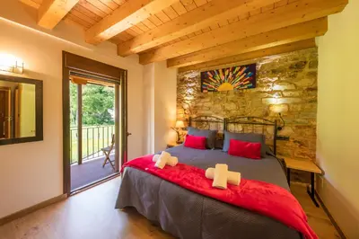 a bedroom with a bed and a stone wall at LA PANDELA in Las Herrerías