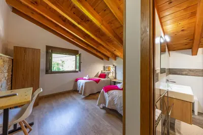 a bedroom with two beds and a desk and a table at LA PANDELA in Las Herrerías