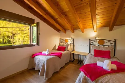 two beds in a room with a window at LA PANDELA in Las Herrerías