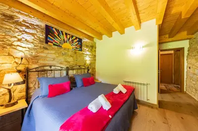 a bedroom with a bed with red pillows at LA PANDELA in Las Herrerías