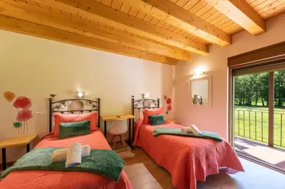 two beds in a room with a window at LA PANDELA in Las Herrerías