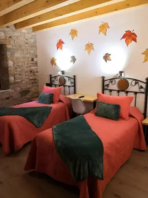 a bedroom with two beds with orange and green at LA PANDELA in Las Herrerías