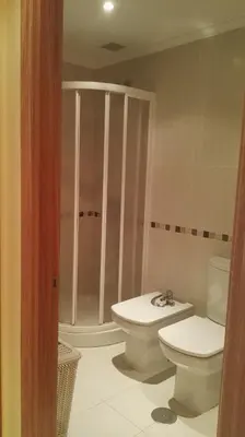 a bathroom with a toilet and a sink and a shower at Apartamentos Rapadoira in Foz