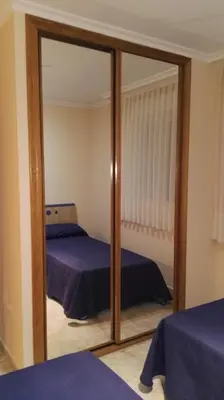 a bedroom with two beds and a mirror at Apartamentos Rapadoira in Foz
