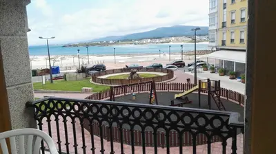 a balcony with a view of the beach and a playground at Apartamentos Rapadoira in Foz