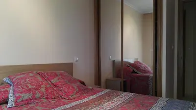a bedroom with a bed with a red comforter and a mirror at Apartamentos Rapadoira in Foz