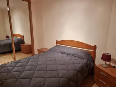 a bedroom with a bed and a mirror at Apartamentos Rapadoira in Foz