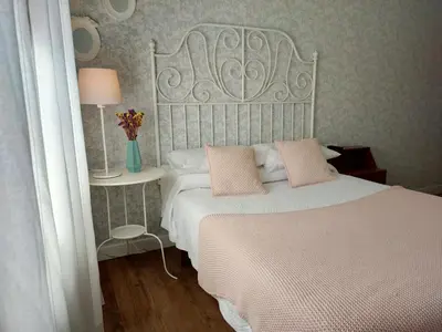 a bedroom with a white bed with pink pillows at Casa castro in Cruces