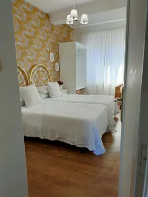 a bedroom with two beds and a mirror at Casa castro in Cruces