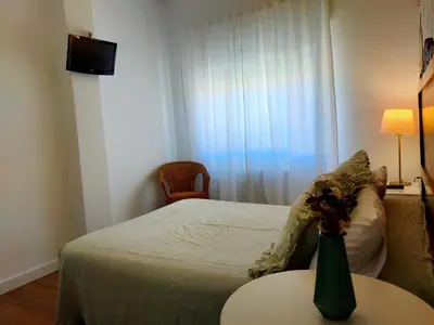 a bedroom with a bed and a table with a vase on it at Casa castro in Cruces