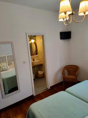 a bedroom with two beds and a mirror and a chair at Casa castro in Cruces