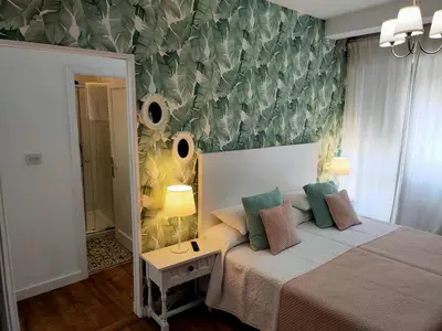 a bedroom with a bed and a wall with leaves at Casa castro in Cruces
