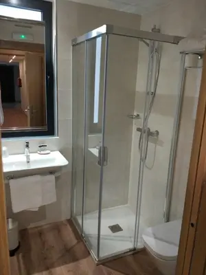 a bathroom with a shower and a toilet and a sink at Casona da Ponte in Portomarin