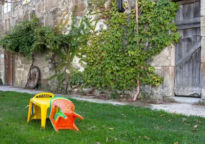 two colorful tables in the grass next to a building at Casa do Comediante in Cerdeira