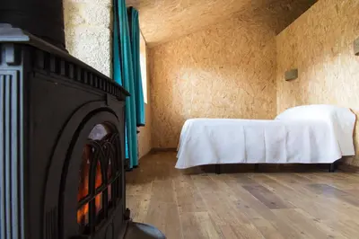 a room with a fireplace and a bed in it at Casa do Comediante in Cerdeira