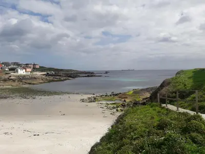 a sandy beach with the ocean in the background at Playa Caosa in San Ciprián