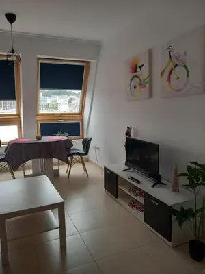 a living room with a tv and a table at Playa Caosa in San Ciprián