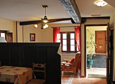 a living room with a table and a chair at Apartamentos El Llago in Boal
