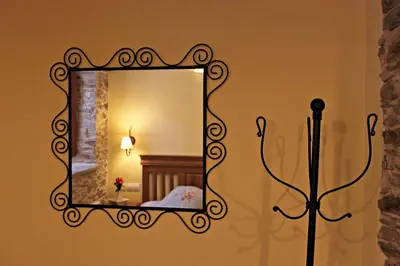 a mirror on a wall with a lamp in a room at Apartamentos El Llago in Boal