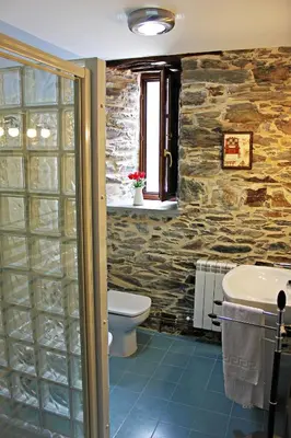 a bathroom with a toilet and a sink at Apartamentos El Llago in Boal