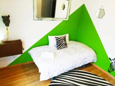 a green and white room with a bed and a mirror at XOXO - Encina in Ponferrada