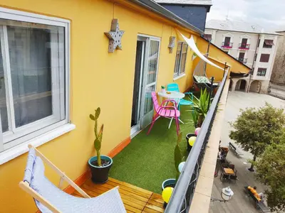 a balcony of a yellow house with a table and chairs at XOXO - Encina in Ponferrada