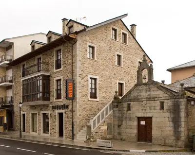 an old brick building on the side of a street at Hostal Raices in Puebla de Sanabria