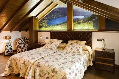a bedroom with a bed with a large window at Hostal Raices in Puebla de Sanabria
