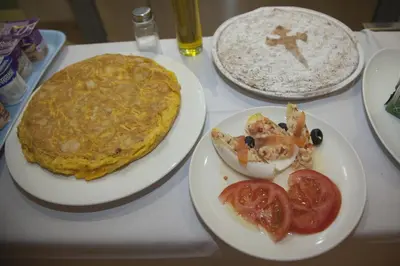 a table with two plates of food and a pizza at Hotel Mar de Plata in Sarria