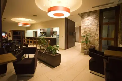 a restaurant with a lobby with tables and chairs at Hotel Mar de Plata in Sarria