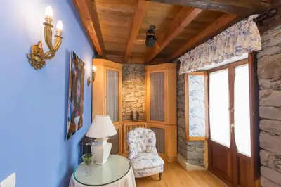 a living room with blue walls and a stone wall at Hotel Rural Casa Xusto in La Caridad