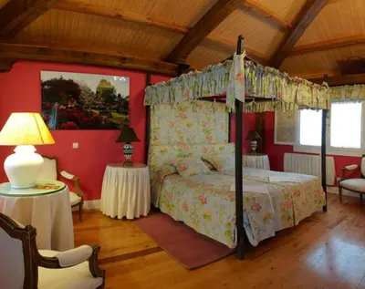 a bedroom with a canopy bed in a room at Hotel Rural Casa Xusto in La Caridad