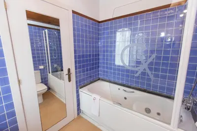 a blue tiled bathroom with a tub and a toilet at Hotel Rural Casa Xusto in La Caridad