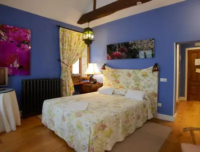 a bedroom with a large bed with blue walls at Hotel Rural Casa Xusto in La Caridad
