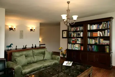 a living room with a couch and a book shelf at Hotel Rural Yeguada Albeitar in Villayón