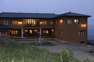 a large house with a fountain in front of it at Hotel Rural Yeguada Albeitar in Villayón